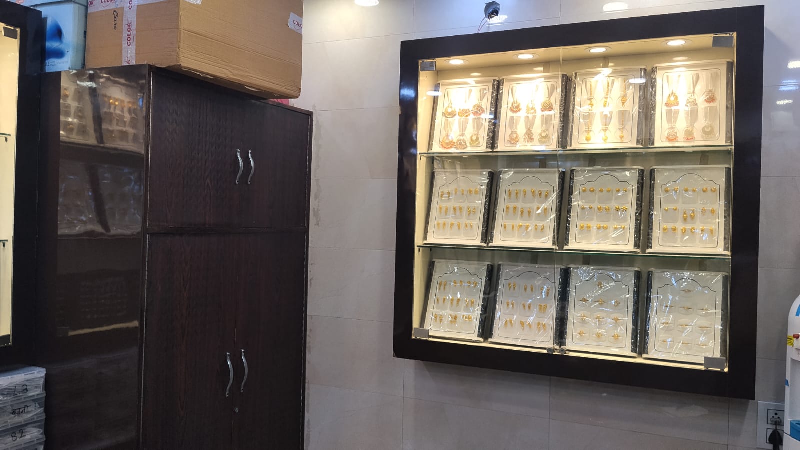 Wall display of gold jhumkas, tops and nose pins